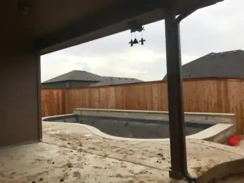 Cedar pergola covers a backyard patio under construction.