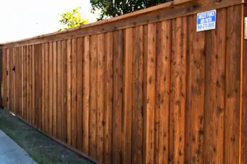 Cedar privacy fence displays a Grizzly Fence and Patio sign.