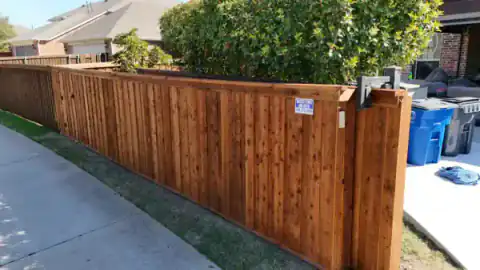 Cedar fence with a Grizzly Fence and Patio yard sign.