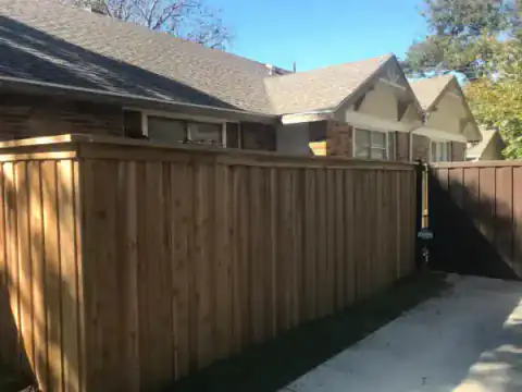 Cedar privacy fence creates a clean corner beside a lawn.