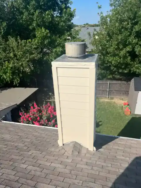 Brick chimney rises beside a North Texas home under construction.